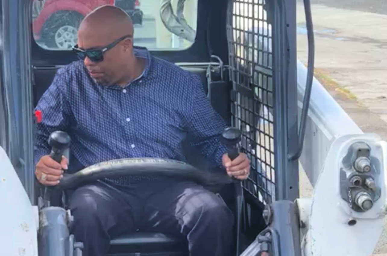 Davidson Charlemagne, territorial director of plant operations at the V.I. Dept. of Education, works a bobcat during a project at John H. Woodson late 2021 to fix a major pipe leak.