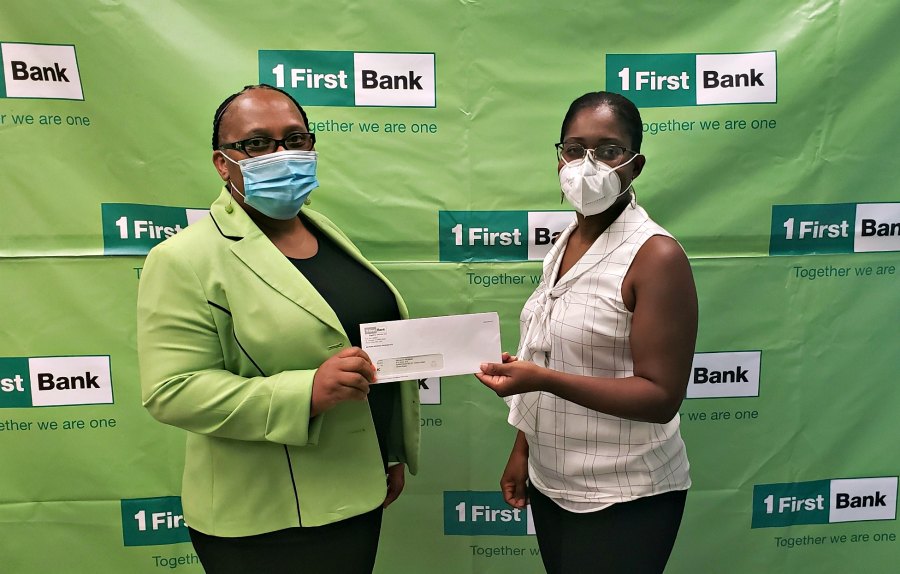 L to R : Ms. Indira Chumney, Regional Risk Operations Manager at FirstBank presents a check to Ms. Resa O’Reilly, Founder & President of Project Promise VI.