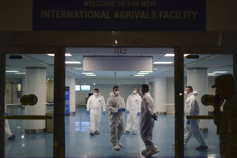National Guard personnel who carry out bio screening on arriving passengers walk around the Luis Muñoz Marin Airport in an effort to detect and isolate the new coronavirus, in Carolina, Puerto Rico.