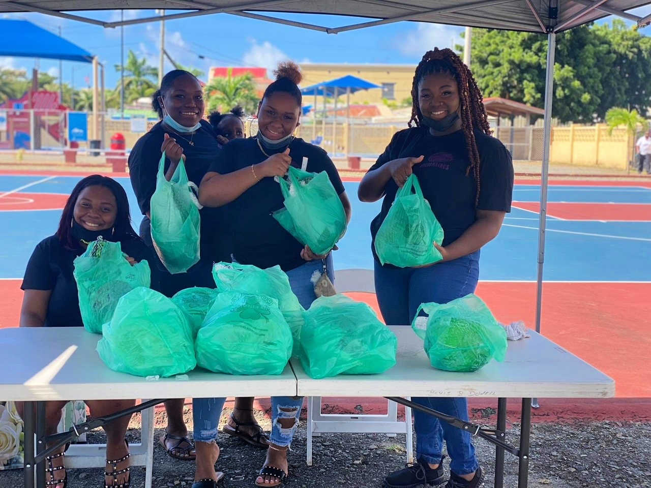 Members of "The Visionaires" hold plastic bags with turkeys during their giveback event on Saturday, Nov. 20, 2021.