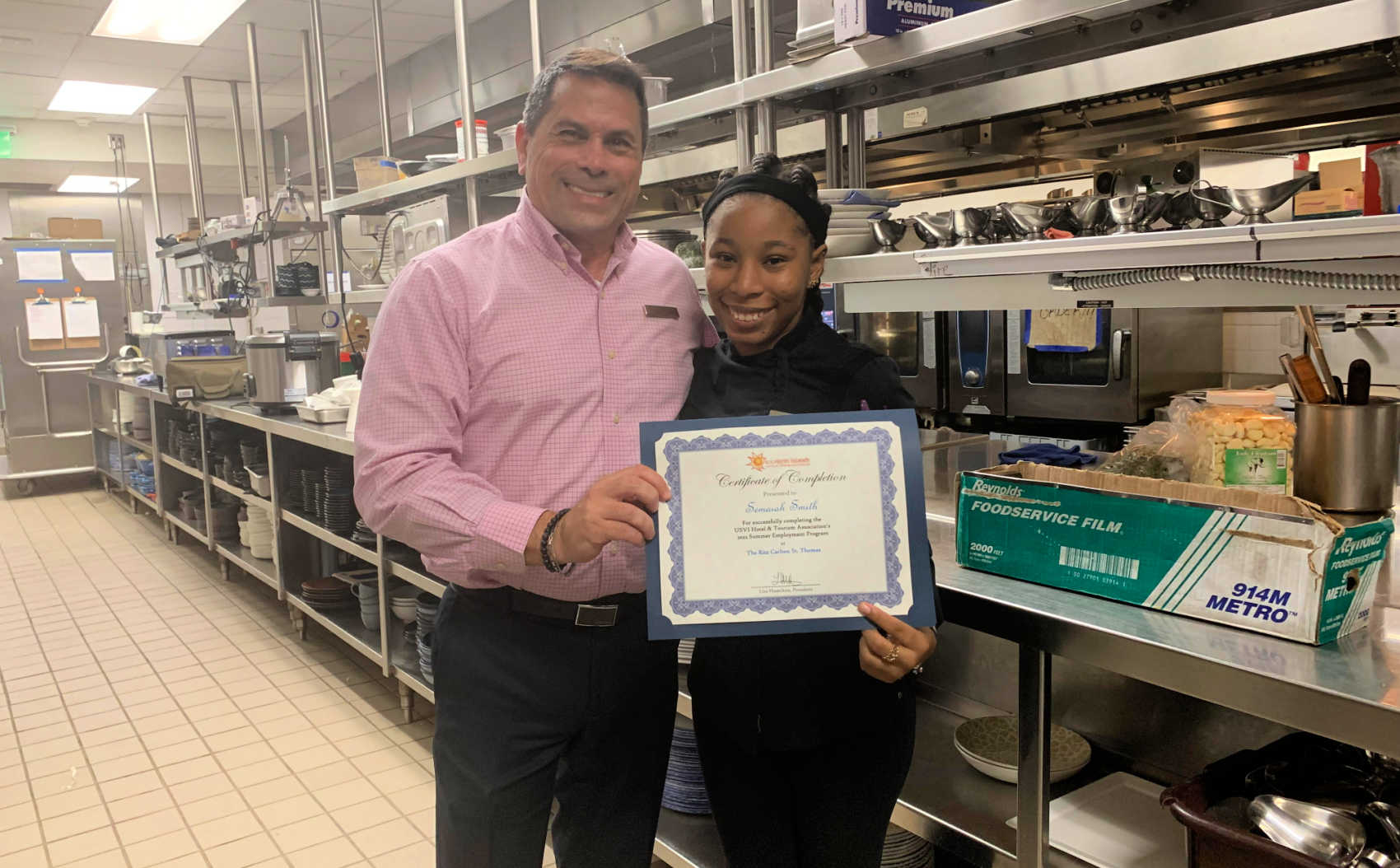 Pedro Hernandez (The Ritz-Carlton, St. Thomas Human Resources) presents student Semaiah Smith with her completion certificate at close of the Summer Employment Program.