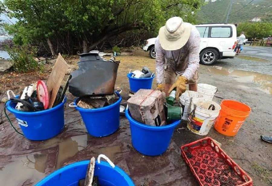 Volunteer with debris pulled out of the mangroves at the 2021 St. John Great Mangrove Cleanup in Coral Bay.