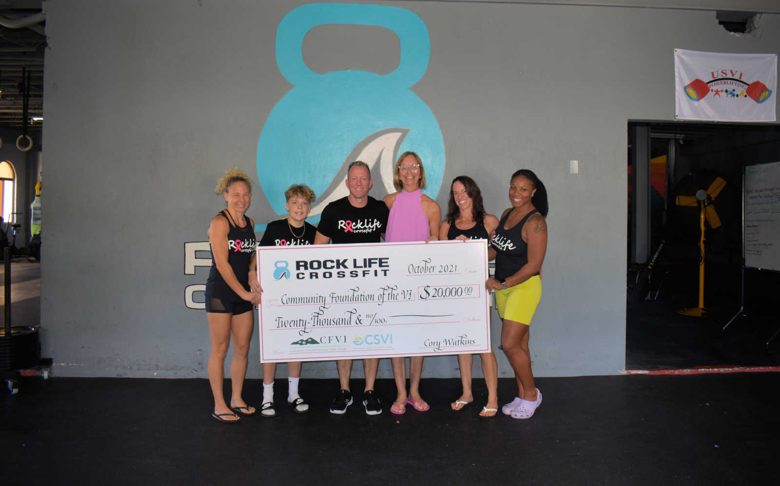 Rock Life Crossfit owner Cory Watkins, center left, and Cancer Support VI Director Barb Michaud, center right during a check presentation event on Sat. Nov. 7, 2021.