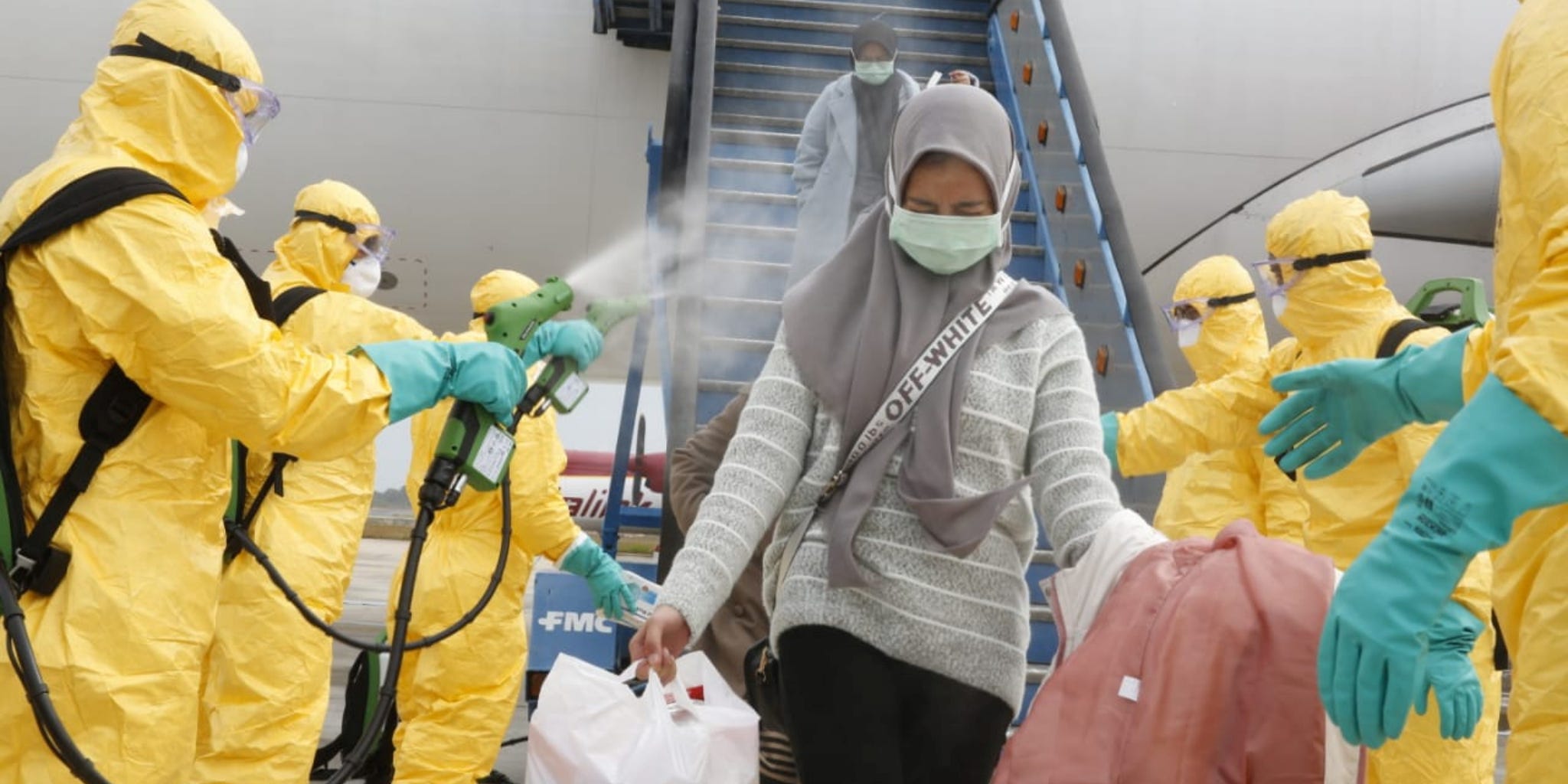 Medical officers spray Indonesian nationals with antiseptic before quarantining them as they arrive in Batam from Wuhan, China, on Sunday.