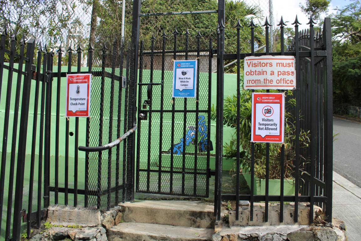 At Joseph Sibilly Elementary School on St. Thomas, COVID-19 signage mounted on the entrance gate.