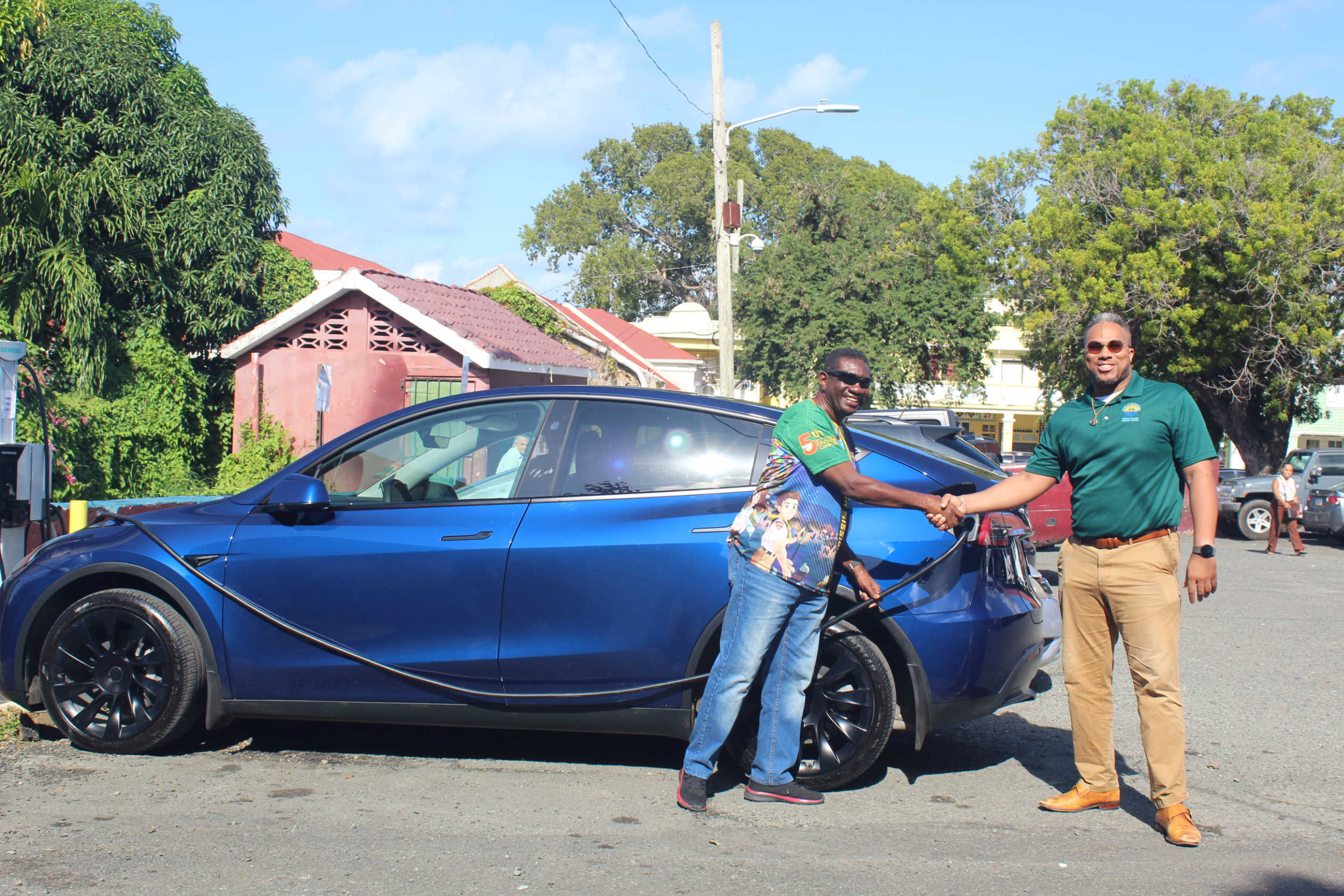 Curtis Flemming, the first to use VIEO’s new EV charger at the Shan Market in Christiansted, shakes hands with VIEO Director Kyle Fleming to mark the milestone in transportation electrification.