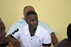 Ashley Scotland, opinions editor at VI Consortium, listens attentively while Pastor Dexter Skepple address men.
