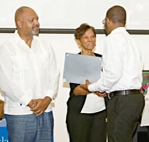 Dr. Doris Battiste congratulated Oldain Claxton, UVI student, at UVI Student Peer Educator ceremony as Sen. Tregenza Roach looks on.