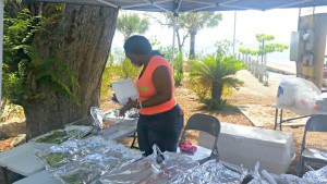 Candice Robinson serving food at the Frederiksted Fish Market located near the Walter IM Hodge Housing Community.