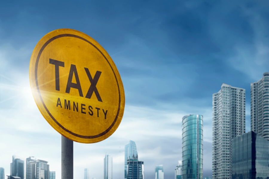 Tax amnesty quotes on the board traffic signs on the outdoor with blue sky and skyscraper background