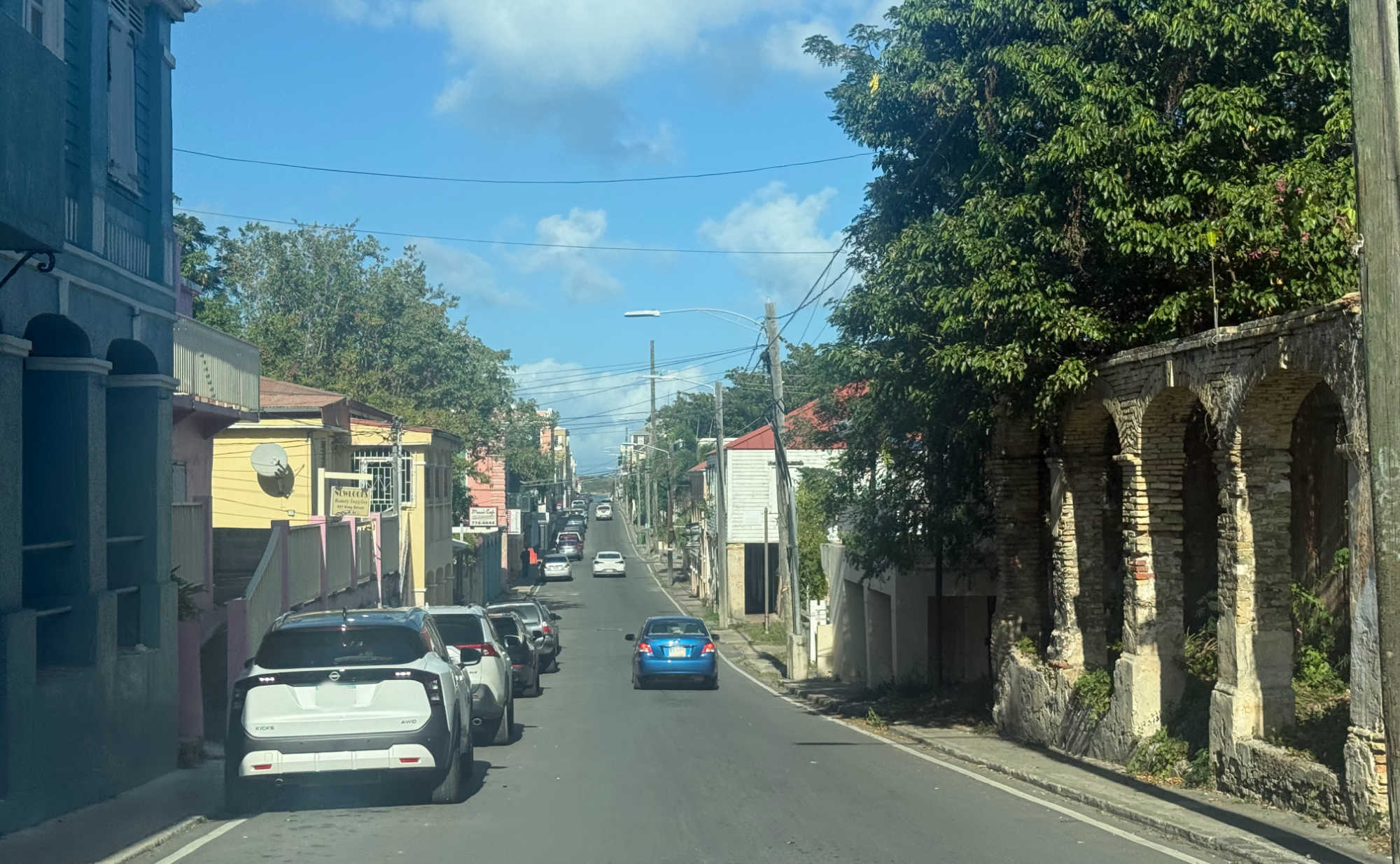 Downtown Christiansted, where several abandoned and deteriorating buildings remain along a main roadway.