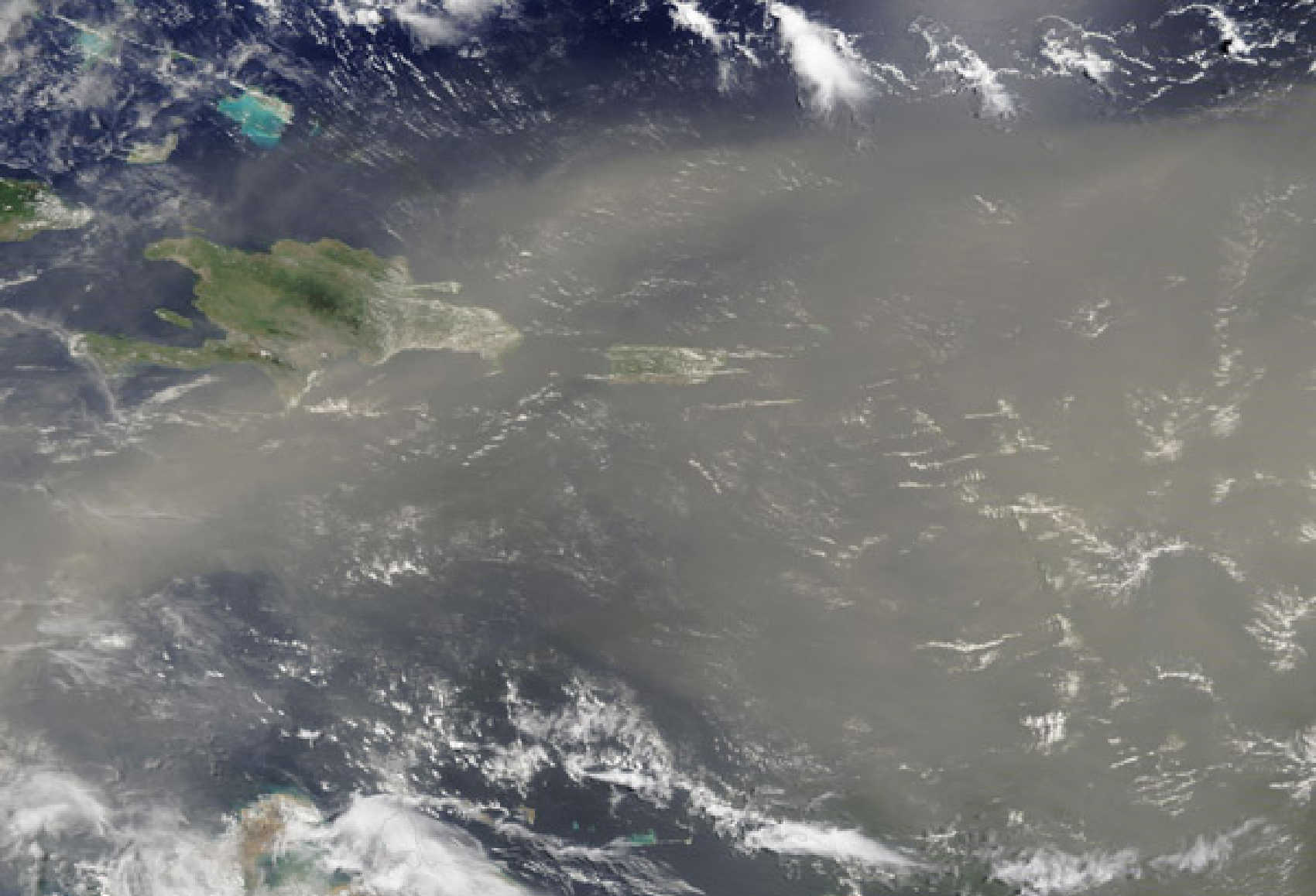 NOAA GOES-19 satellite imagery shows Saharan dust spreading across the Caribbean as a dense plume approaches the U.S. Virgin Islands, with widespread haze and reduced air quality expected beginning Thursday night.