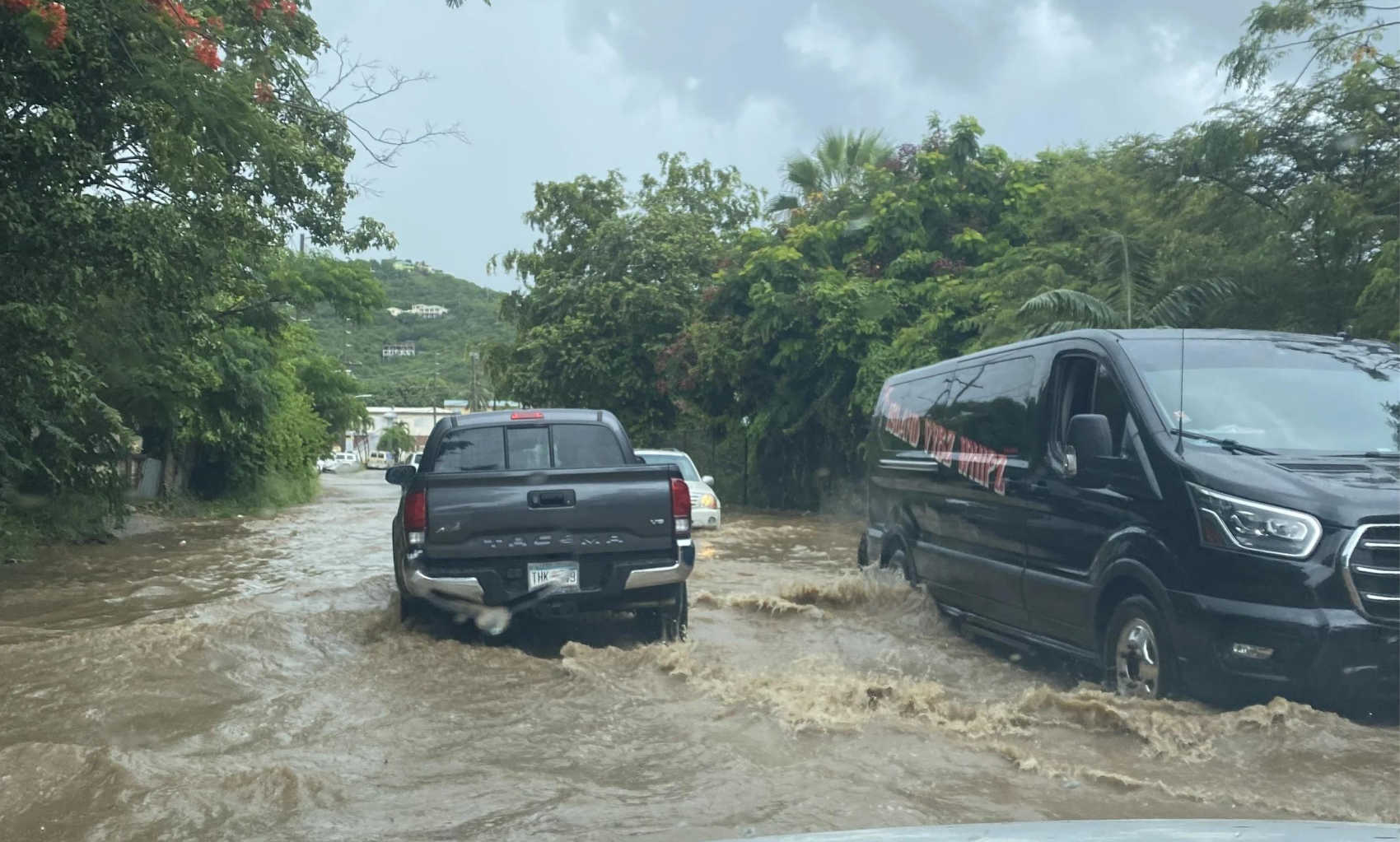 Vehicles navigate a flooded roadway in the U.S. Virgin Islands. FEMA's new online service now allows eligible property owners in the territory to purchase federal flood insurance directly through FloodSmart.gov.