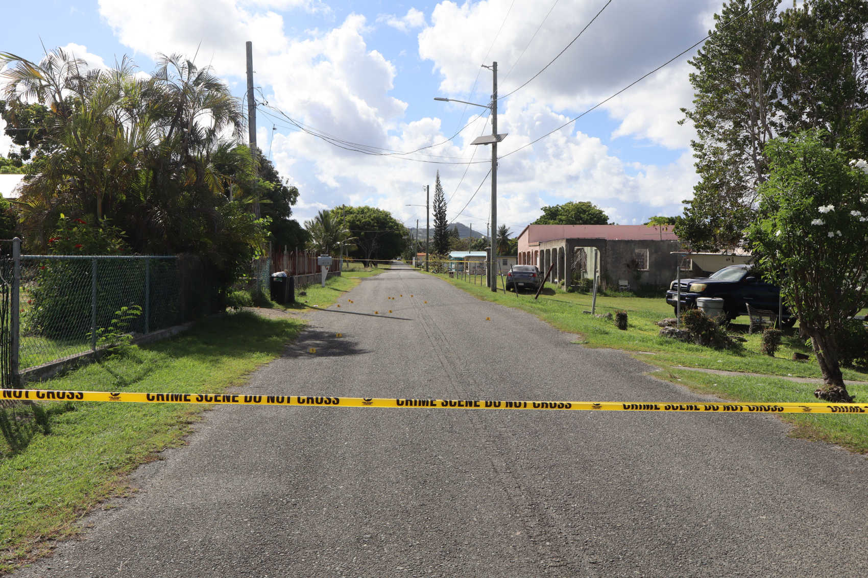 Crime scene tape and evidence markers line the roadway at Princess Villas in La Grande Princesse, where 29-year-old Ricardo Richards was fatally shot Sunday afternoon.
