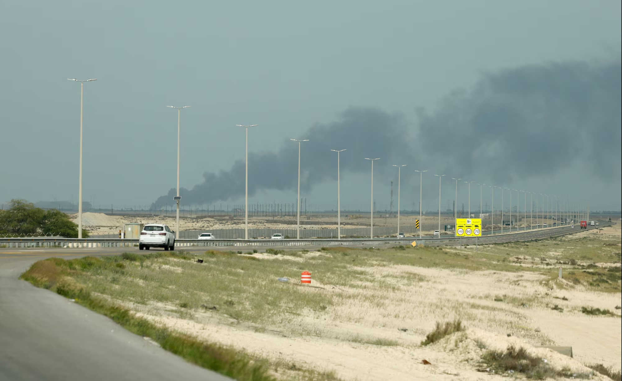 Dark smoke rises near a highway in Saudi Arabia following attacks on the kingdom’s oil infrastructure, as escalating Middle East tensions push Brent crude higher and raise concerns about fuel costs in the USVI.