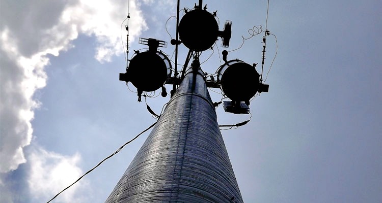 A composite utility pole carries electrical equipment beneath a bright sky. WAPA is moving ahead with long-delayed pole replacement on St. John park lands after FEMA and NPS resolved permitting issues.